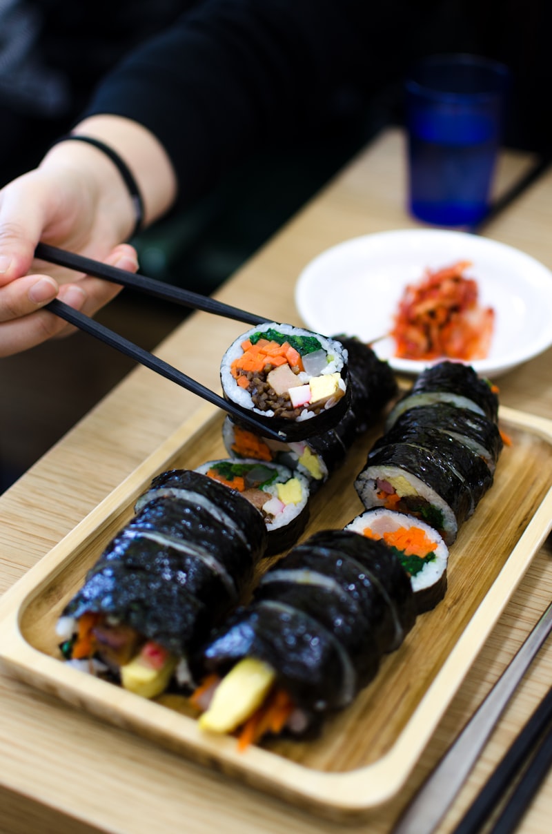 Tuna and kimchi kimbap on a wooden tray